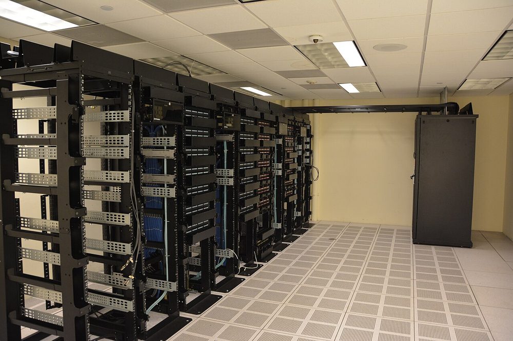 Rows of server racks with patch cabling in a quiet data centre